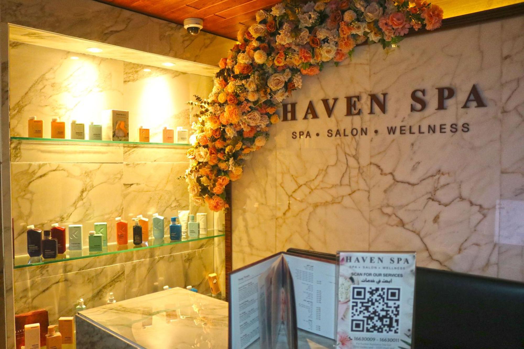 Lagoona Beach Luxury Resort And Spa Manáma Kültér fotó The photo shows the interior of a spa called "Haven Spa." The wall is decorated with beautiful artificial flowers, creating an inviting atmosphere. There are several shelves displaying various colorful bottles and products, likely for skincare or wel
