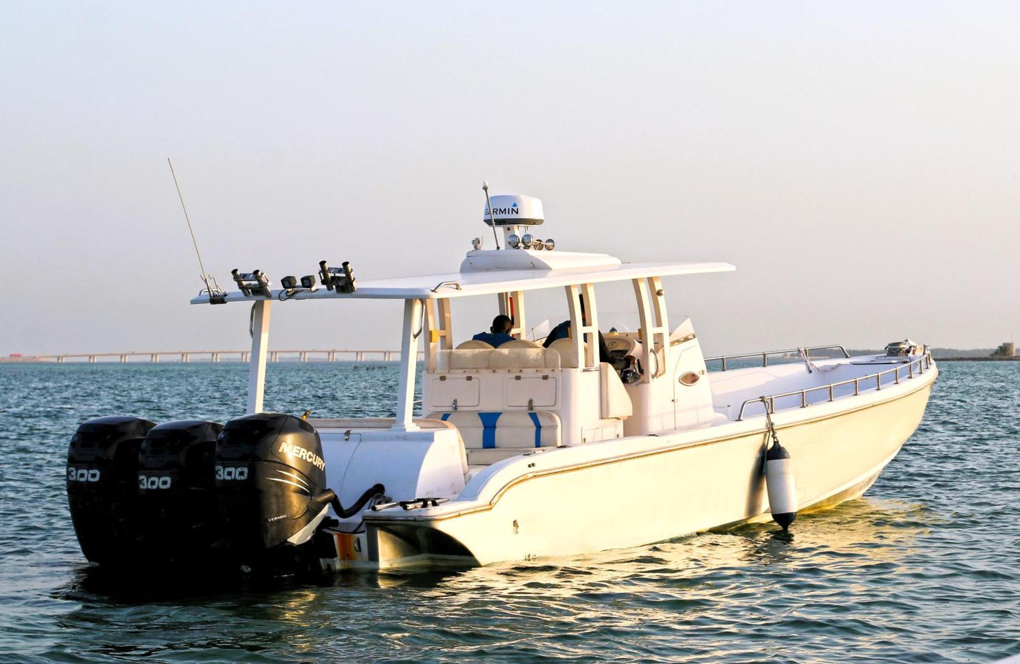 Lagoona Beach Luxury Resort And Spa Manáma Kültér fotó The photo shows a large, white motorboat equipped with three powerful outboard engines at the stern. The boat has a sleek design, with a spacious open deck and a covered cabin area that likely provides shelter and controls for navigation. The scene i