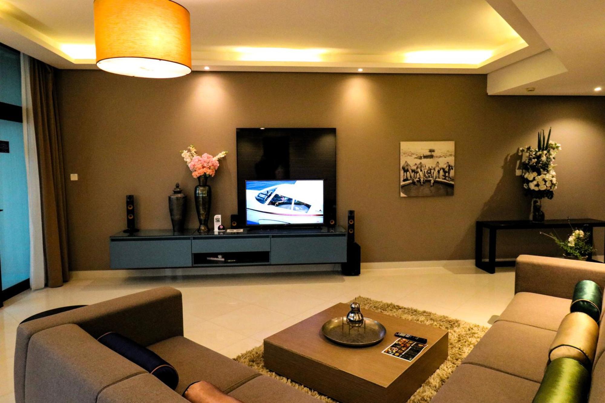 Lagoona Beach Luxury Resort And Spa Manáma Kültér fotó The photo shows a modern living room with a neutral color palette. Key features include:

- A comfortable seating area with a sofa arranged around a coffee table.
- A minimalist coffee table with a decorative item on top.
- A large flat-screen televi